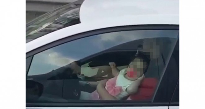 Kucağında bebek ile direksiyon başına geçen sürücü kamerada