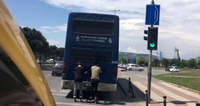 Otobüsün arkasında seyahat edip akrobatik hareketler yaptılar